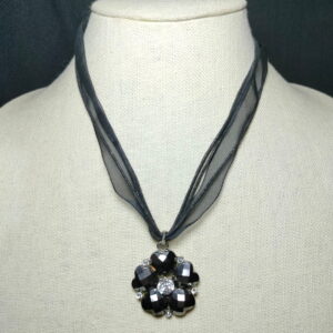 A black flower pendant with lace necklace
