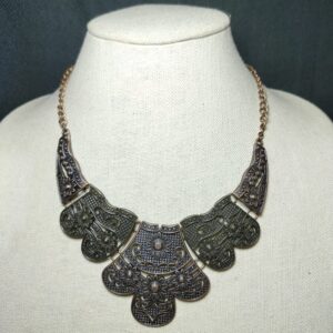 antiqued brass and copper plates connect below the collar.Features an adjustable clasp closure
