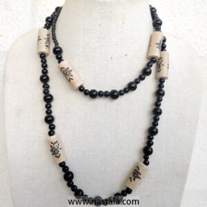 A necklace with black beads and beige floral patterned accents | قلادة مع خرز أسود وتفاصيل مزخرفة بالأزهار باللون البيج
