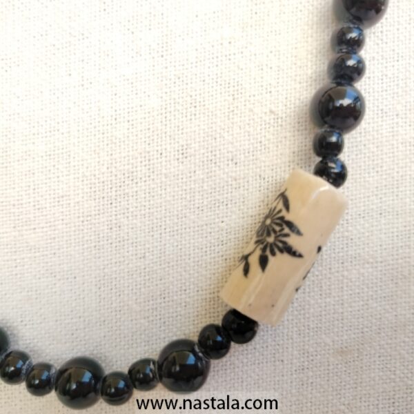A necklace with black beads and beige floral patterned accents | قلادة مع خرز أسود وتفاصيل مزخرفة بالأزهار باللون البيج - Image 3