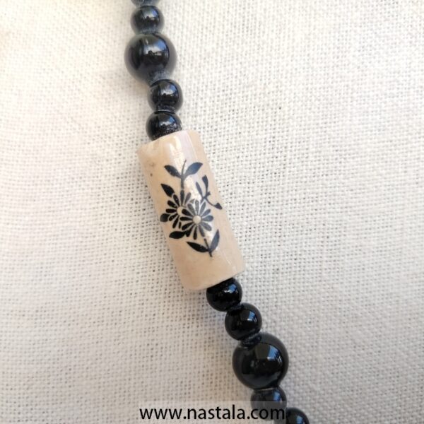 A necklace with black beads and beige floral patterned accents | قلادة مع خرز أسود وتفاصيل مزخرفة بالأزهار باللون البيج - Image 4