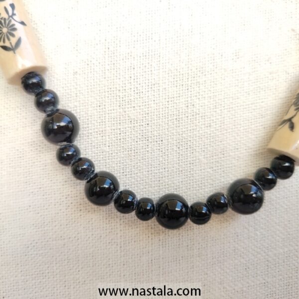 A necklace with black beads and beige floral patterned accents | قلادة مع خرز أسود وتفاصيل مزخرفة بالأزهار باللون البيج - Image 6