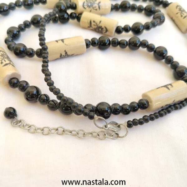 A necklace with black beads and beige floral patterned accents | قلادة مع خرز أسود وتفاصيل مزخرفة بالأزهار باللون البيج - Image 2