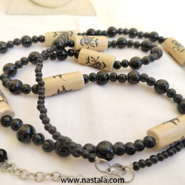A necklace with black beads and beige floral patterned accents | قلادة مع خرز أسود وتفاصيل مزخرفة بالأزهار باللون البيج - Image 5