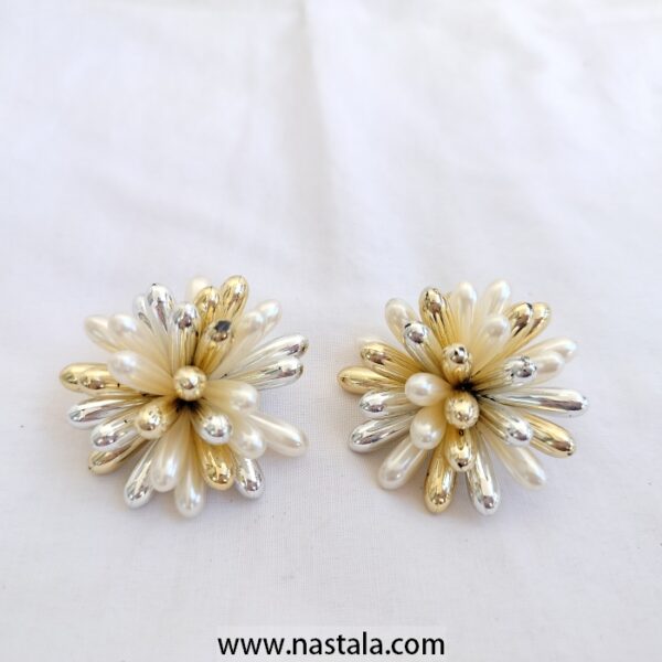 A pair of flower-shaped earrings with gold and silver accents | أقراط بتصميم زهري مع تفاصيل ذهبية وفضية