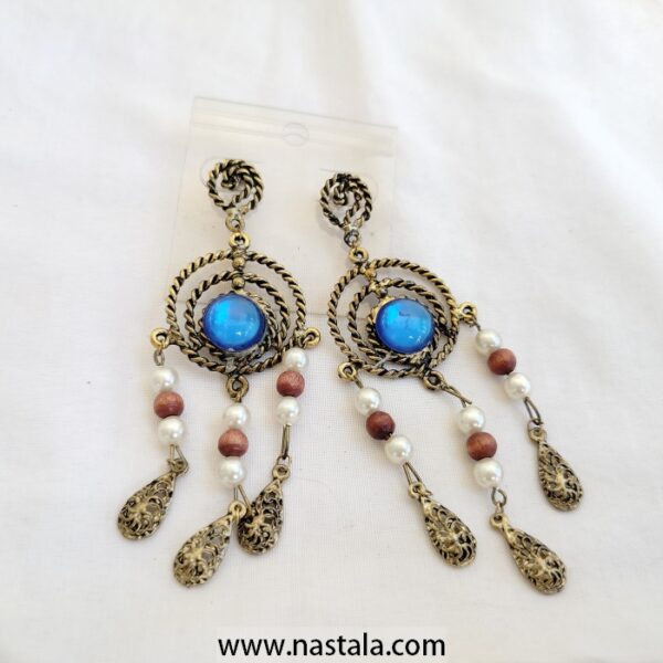 A pair of vintage-style earrings with blue accents and dangling beads | أقراط بتصميم قديم مع لمسات زرقاء وخرز متدلي