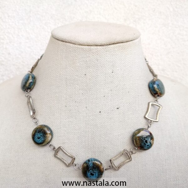 A necklace with blue beads and geometric silver accents | قلادة مع خرز أزرق وتفاصيل هندسية فضية