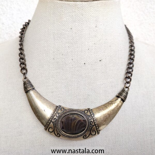 A vintage-inspired necklace with a metal pendant and intricate design | قلادة مستوحاة من الطراز القديم مع قلادة معدنية بتصميم معقد