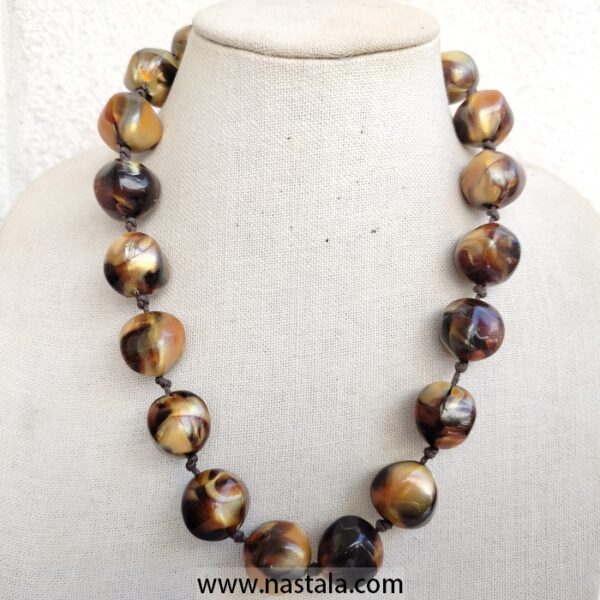 A necklace with large, round plastic beads in warm tones | قلادة من خرز بلاستيكي كبير ودائري بألوان دافئة