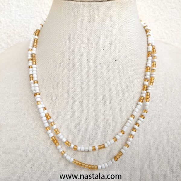 A double-strand necklace with white and gold beads | قلادة ذات خيطين من الخرز الأبيض والذهبي