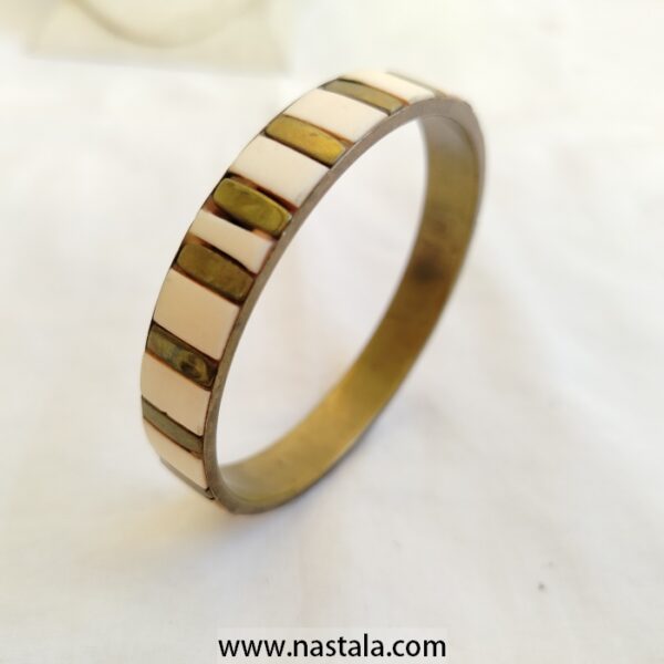 A bangle with a striped pattern of ivory and metallic tiles | سوار بنمط مخطط من بلاطات عاجية ومعدنية