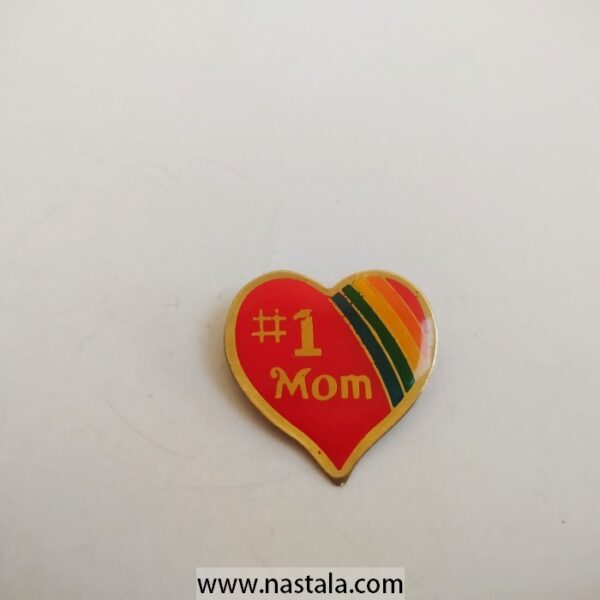 A heart-shaped pin that says "#1 Mom" | دبوس على شكل قلب مكتوب عليه "#1 Mom"
