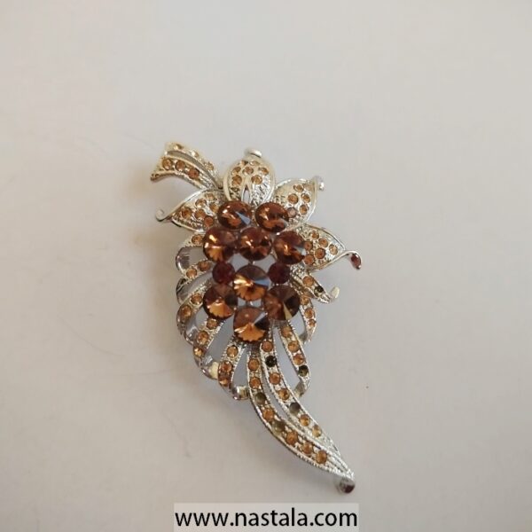 A shimmering floral brooch with amber and clear rhinestones | دبوس مزخرف بشكل زهرة مع أحجار الراين الكهرماني والشفافة