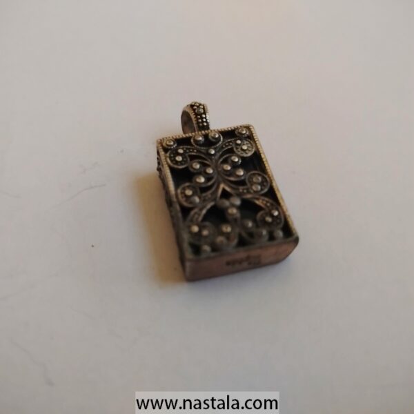 A vintage-style decorative pendant with intricate detailing | قلادة بتصميم قديم مع تفاصيل معقدة